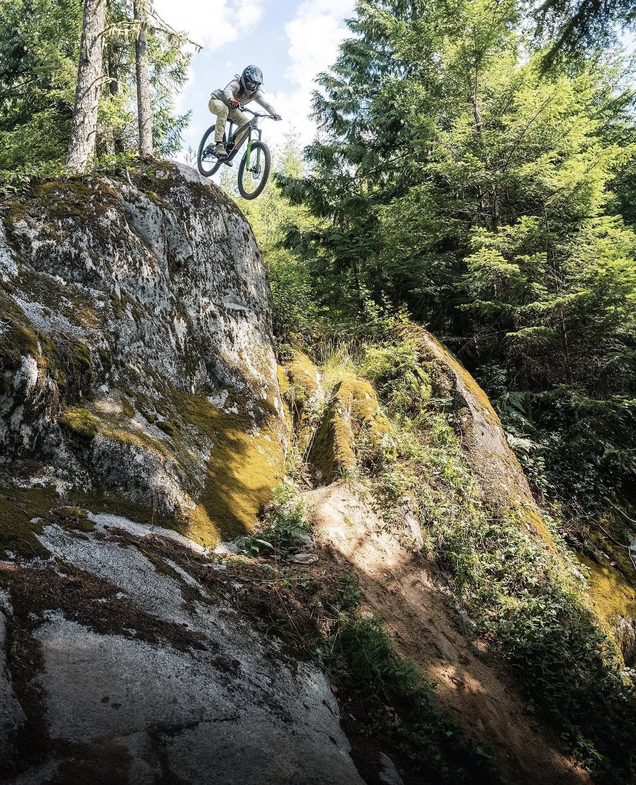 Rider dropping off a mossy PNW rock face