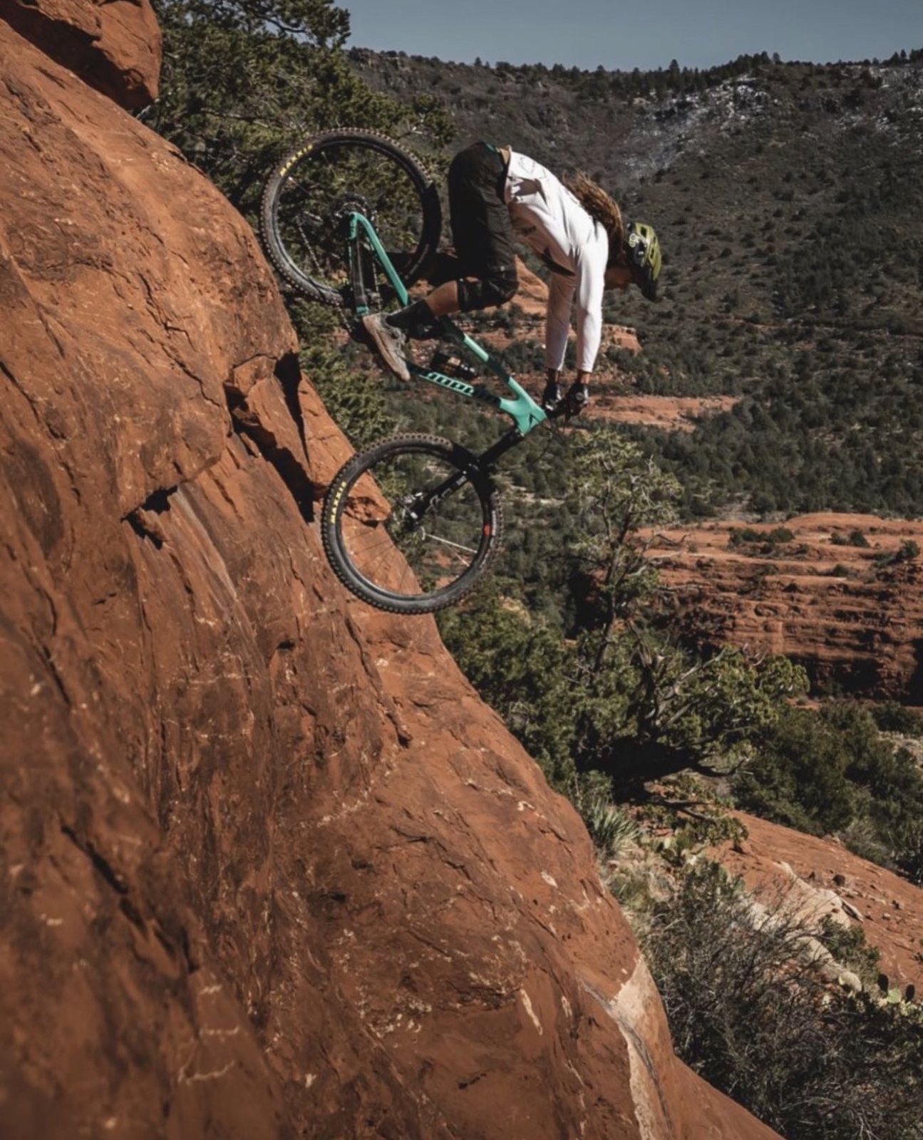 Rider on a steep red rock drop in Sedona Arizona